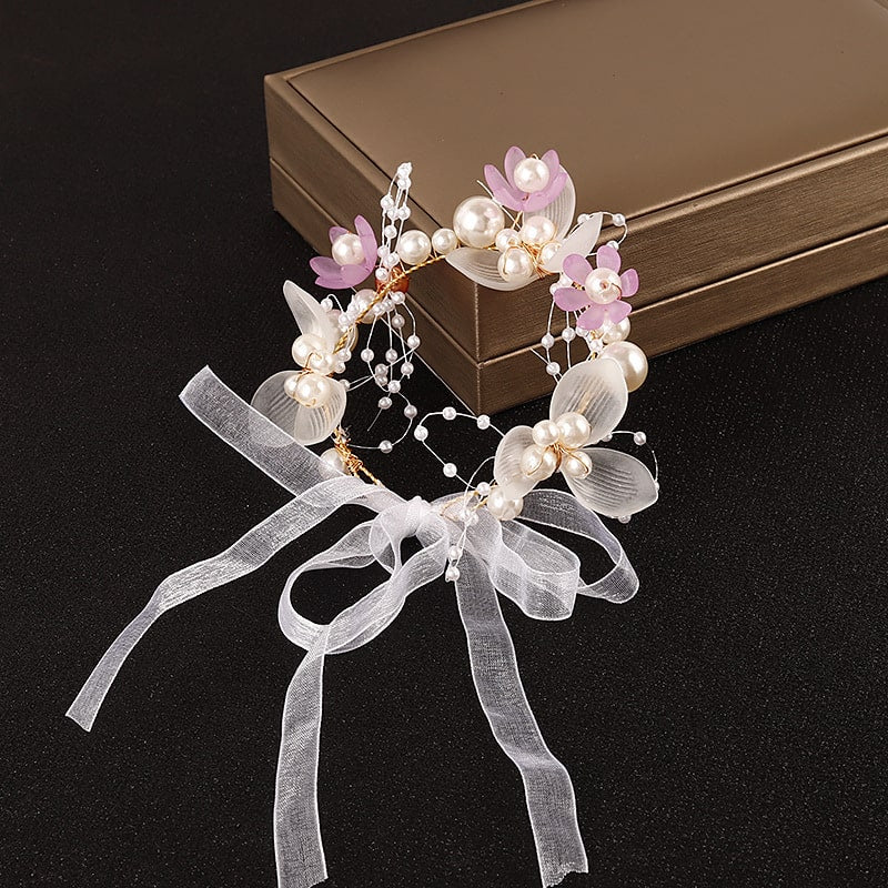 Delicate wrist corsage adorned with pink and white pearls and flowers