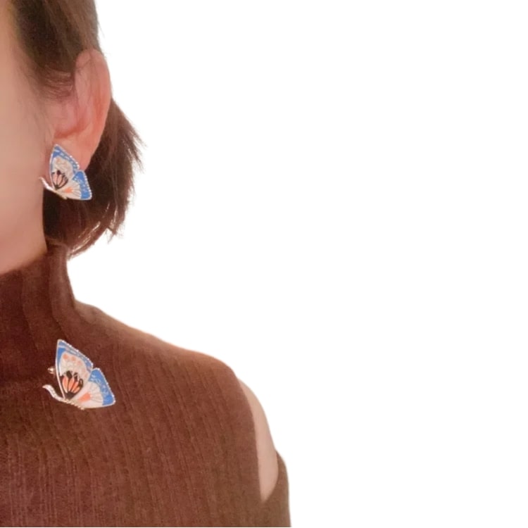 A vintage butterfly enamel brooch pinned to a stylish dress, enhancing the outfit's elegance and charm, perfect for women who appreciate timeless fashion