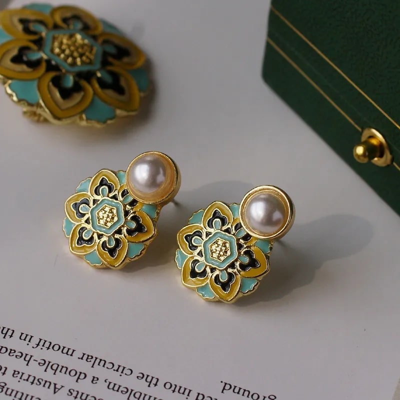 A pair of earrings with a flower design and a pearl, adding timeless elegance and a touch of medieval vibe to any ensemble.