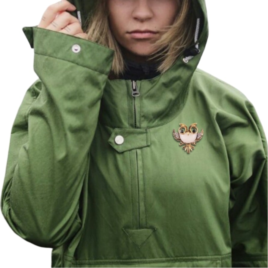 woman wearing green rain jacket with hood, antique owl with glasses brooch, a charming accessory for nature lovers and glasses wearers