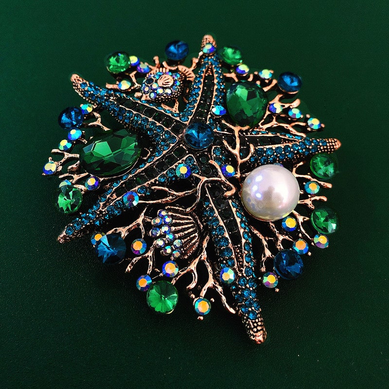 pearl starfish sea life brooch featuring green and blue stones
