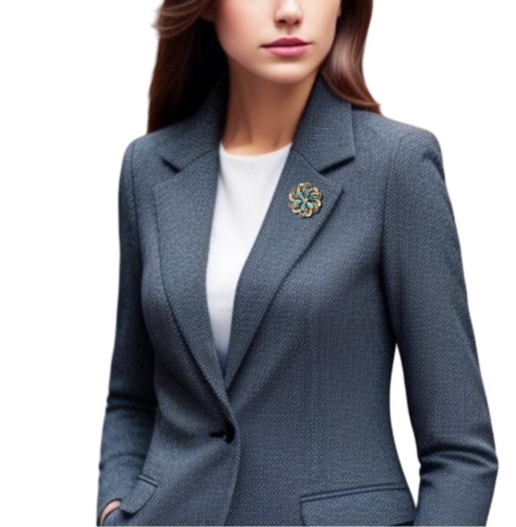 woman in a suit and blazer showcasing a rhinestone round flower crystal brooch in sea green and golden