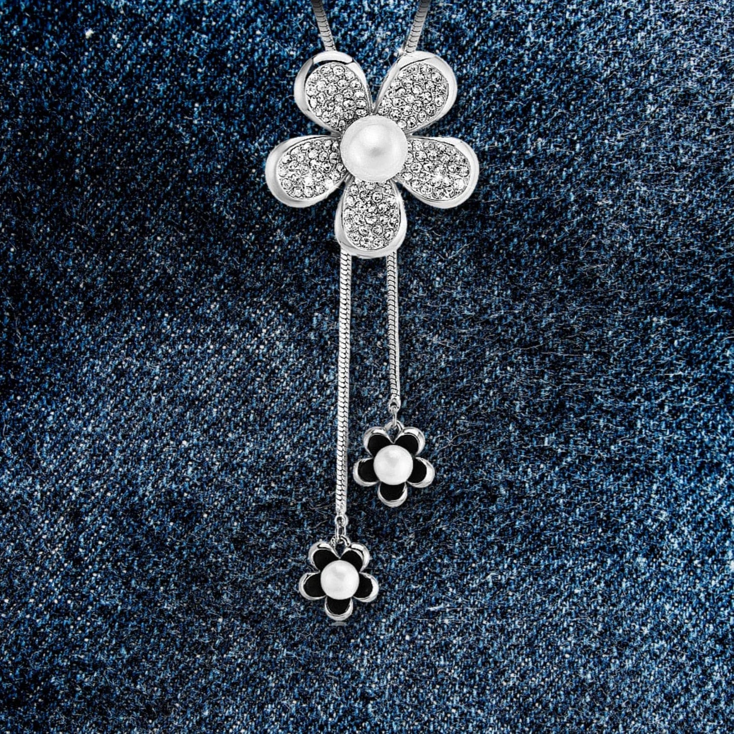 A black and white flower pendant necklace with simulated pearl and rhinestones