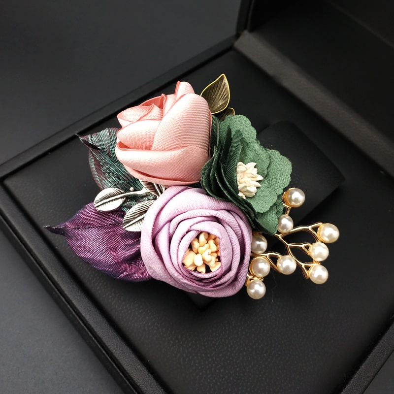 Feel the allure of this brooch, where fabric blooms meet lustrous pearls in a stunning display of femininity