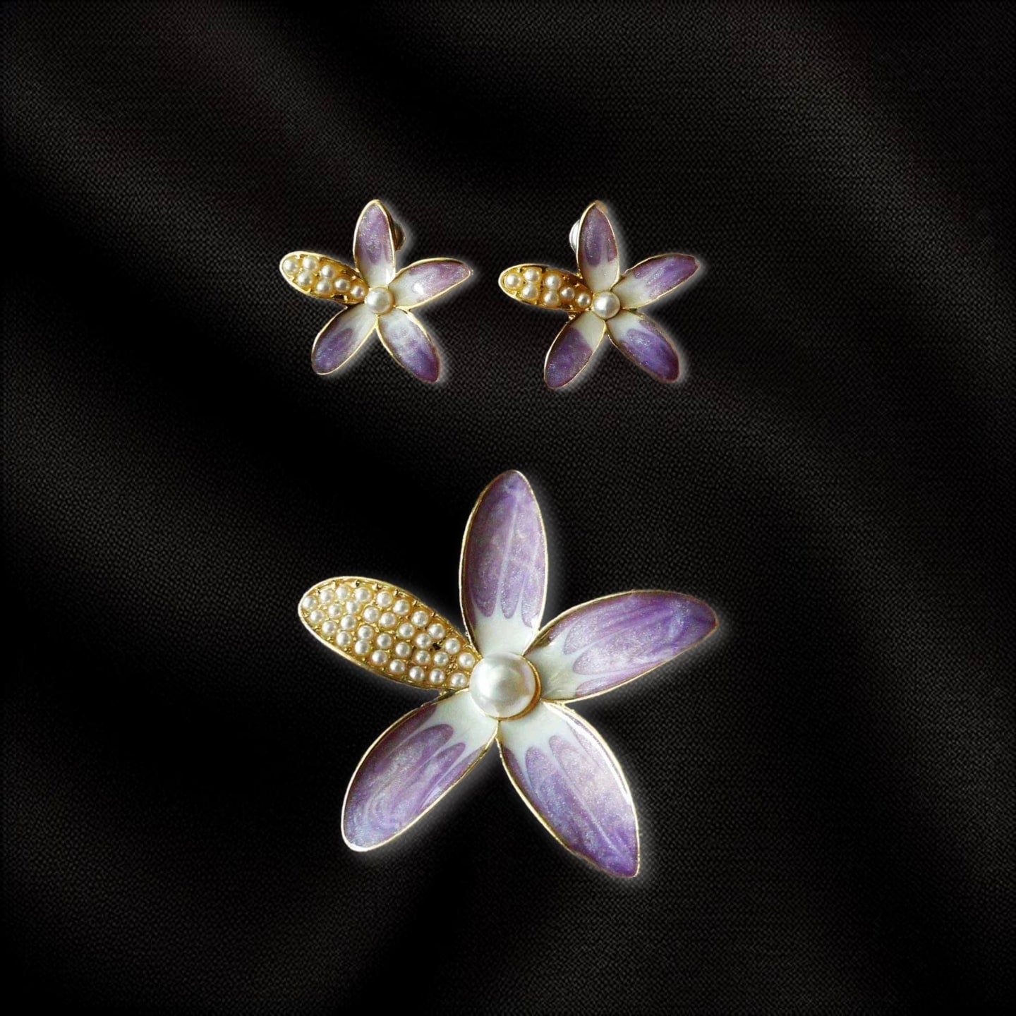 a pair of purple and white flowers with pearls