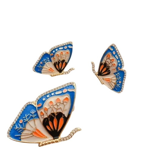 A beautiful vintage butterfly enamel brooch and ear studs set, intricately designed with vibrant colors, displayed on a delicate lace background