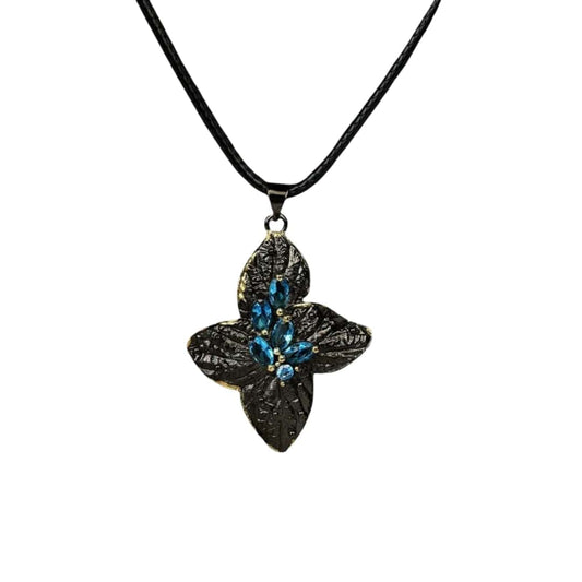 modern women's necklace with a gothic and marine life-inspired black and blue flower pendant set with blue gemstones.
