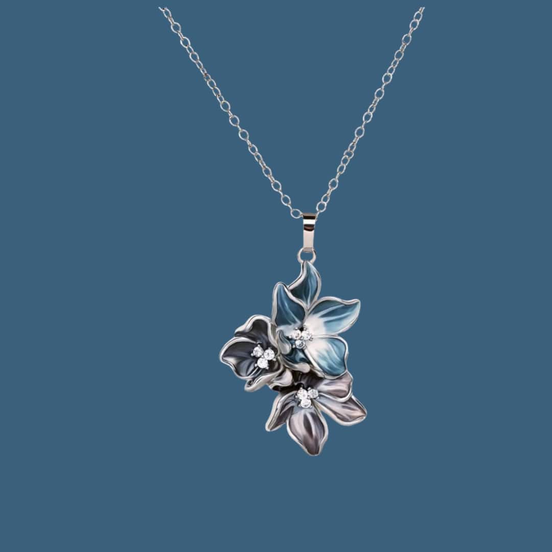 Blue and white enamel flower pendant on silver chain, adorned with rhinestones for a sparkling touch.