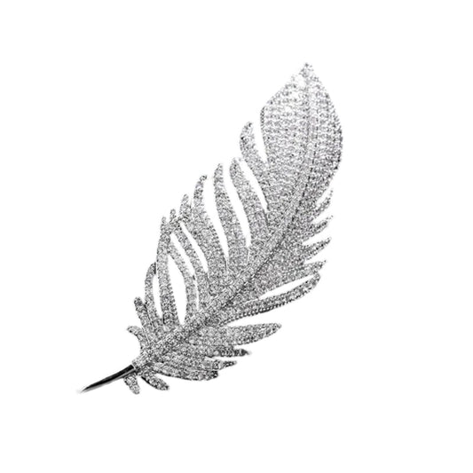 A luxurious diamond feather brooch on a white background, inlaid with countless small rhinestones, shimmering with elegance and class