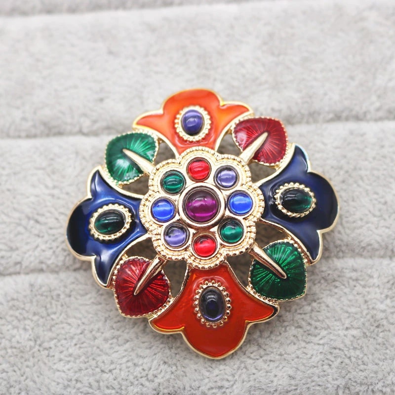 vibrant brooch with a floral design, adorned with multi colorued stones, adding glamour and a vintage feel to any dress